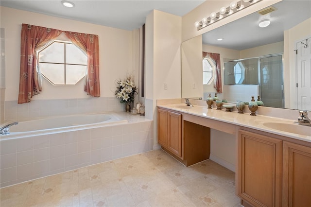 bathroom featuring double vanity, a shower stall, a garden tub, and a sink