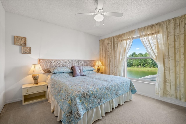 carpeted bedroom featuring baseboards, a textured ceiling, and ceiling fan