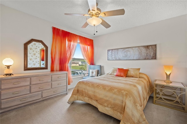 bedroom with a textured ceiling, a ceiling fan, and light carpet