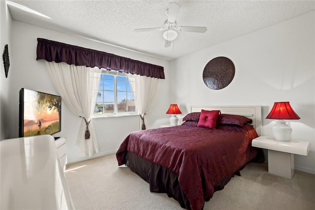 bedroom with ceiling fan, carpet flooring, baseboards, and a textured ceiling