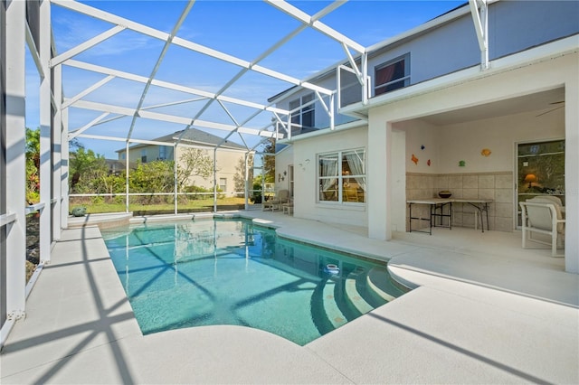 outdoor pool featuring glass enclosure, a patio area, and outdoor dry bar