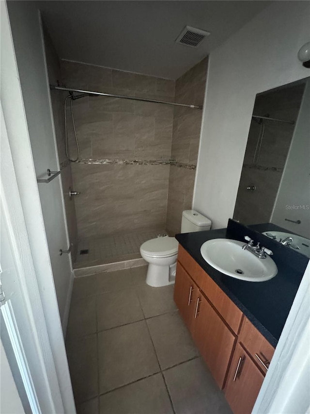 445 Fountainhead Cir Unit 264, Kissimmee, FL 34741 - full bathroom featuring visible vents, toilet, a tile shower, tile patterned floors, and vanity
