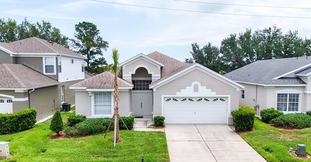 8204 Fan Palm Way, Kissimmee, FL 34747 - view of front of house featuring stucco siding, a garage, driveway, and a front yard