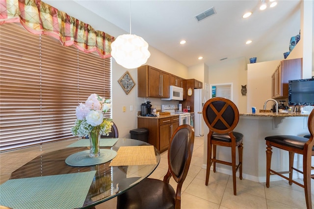 8204 Fan Palm Way, Kissimmee, FL 34747 - dining space featuring light tile patterned floors, recessed lighting, and vaulted ceiling