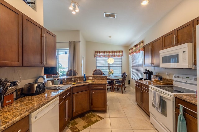 8204 Fan Palm Way, Kissimmee, FL 34747 - kitchen with white appliances, vaulted ceiling, a sink, light tile patterned floors, and a peninsula