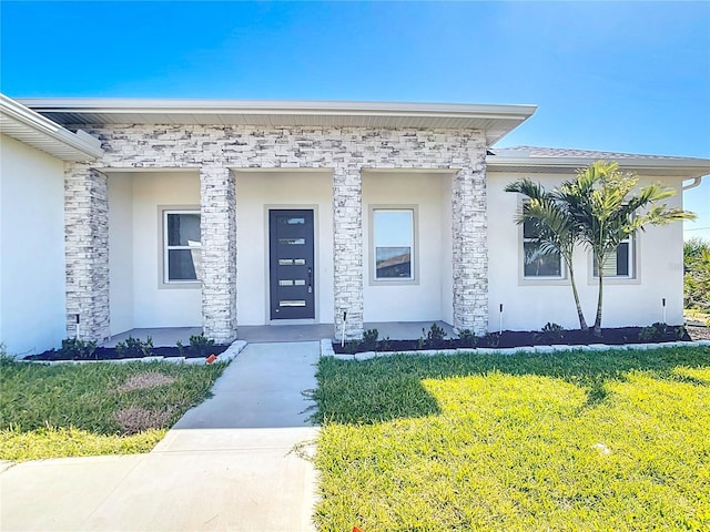 doorway to property featuring a lawn and stucco siding