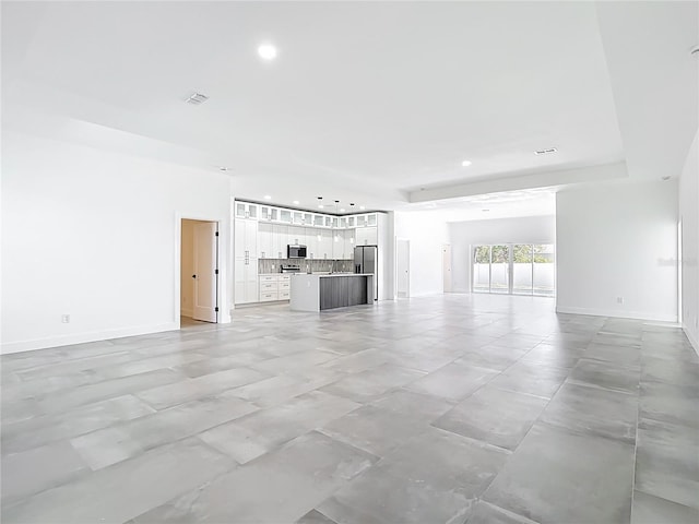 unfurnished living room featuring visible vents, recessed lighting, and baseboards