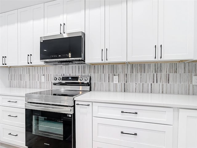 kitchen featuring decorative backsplash, white cabinets, appliances with stainless steel finishes, and light countertops