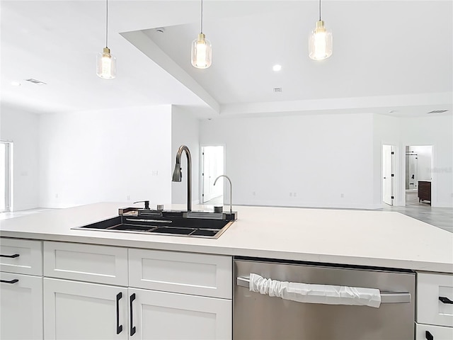 kitchen with stainless steel dishwasher, open floor plan, white cabinetry, and a sink