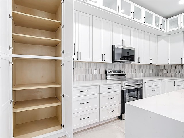 kitchen featuring open shelves, tasteful backsplash, white cabinetry, appliances with stainless steel finishes, and light countertops