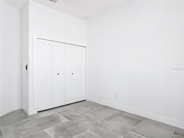 unfurnished bedroom featuring baseboards and a closet