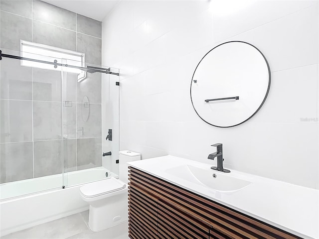 full bathroom with vanity, toilet, tile walls, and shower / bath combination with glass door