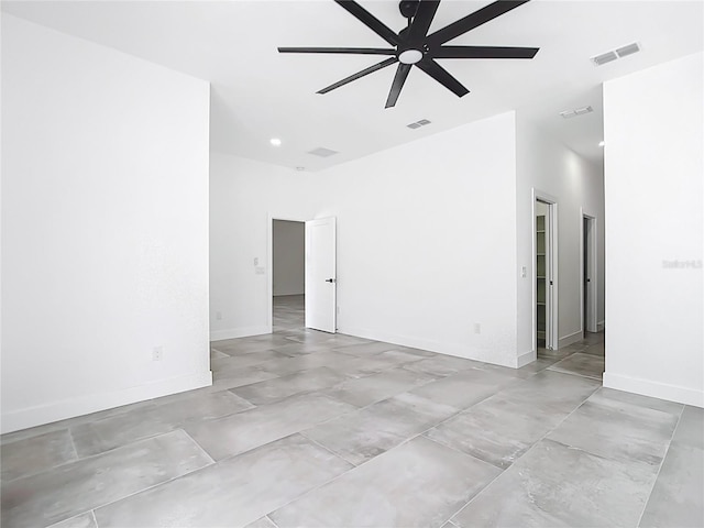 empty room featuring visible vents, baseboards, a high ceiling, and ceiling fan