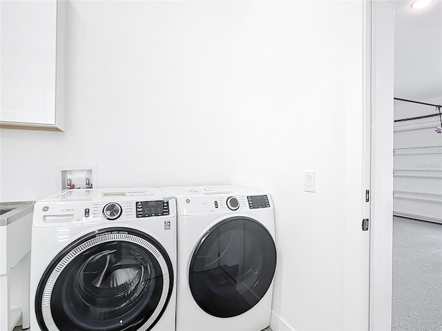 laundry room with a sink, cabinet space, and independent washer and dryer