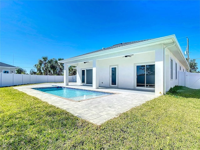 rear view of house featuring a yard, a fenced backyard, ceiling fan, stucco siding, and a patio area