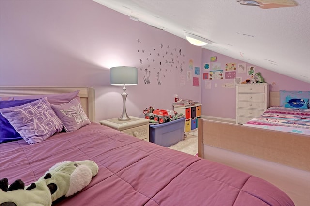 bedroom featuring vaulted ceiling and a textured ceiling