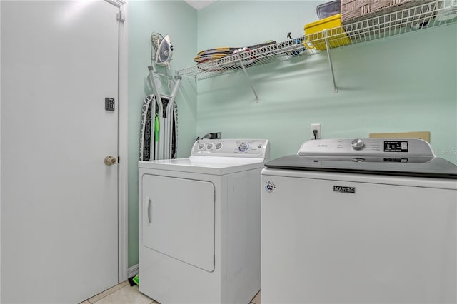 laundry area with laundry area, light tile patterned flooring, and washer and dryer