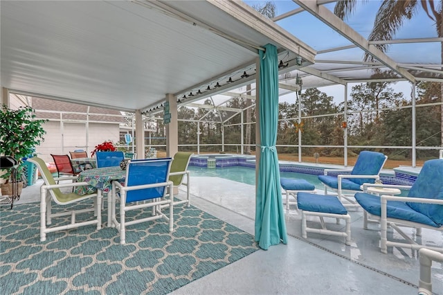 view of patio / terrace featuring glass enclosure and a pool with connected hot tub