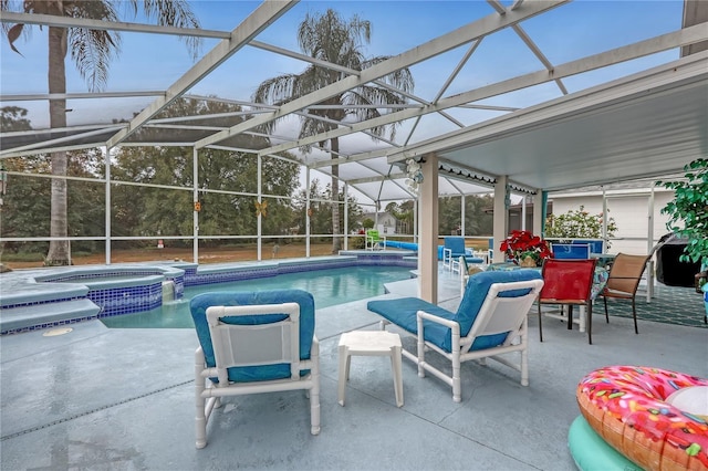 view of swimming pool with a pool with connected hot tub, glass enclosure, and a patio