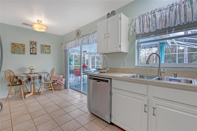 kitchen with light tile patterned floors, a sink, white cabinets, light countertops, and dishwasher