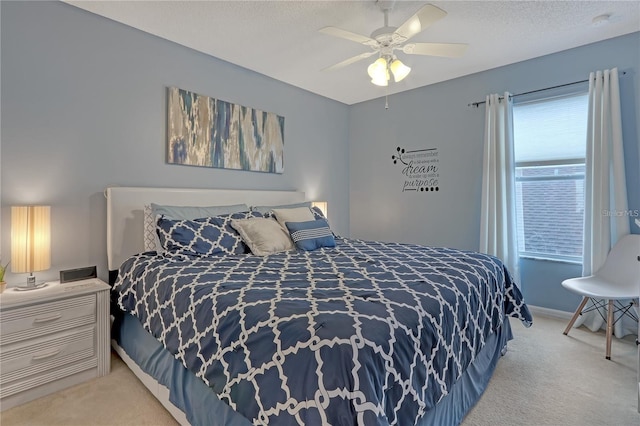 bedroom featuring light carpet, ceiling fan, a textured ceiling, and baseboards