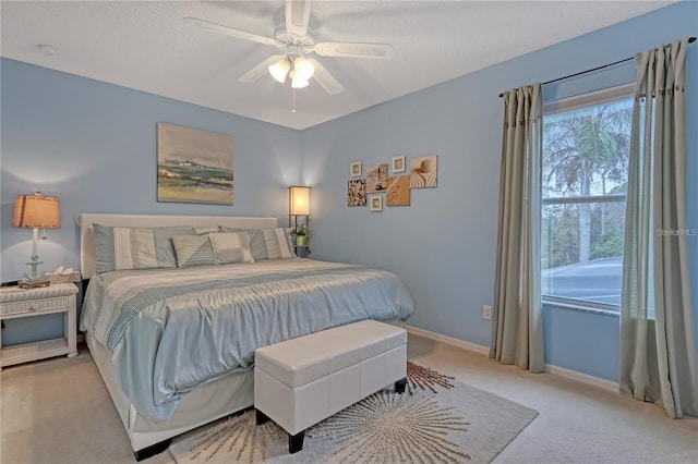 bedroom featuring light carpet, ceiling fan, and baseboards