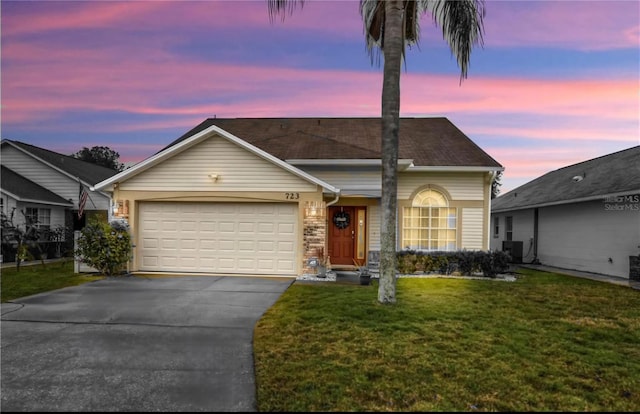view of front facade with an attached garage, driveway, cooling unit, and a front yard