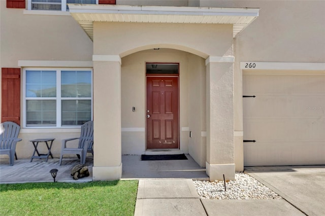 property entrance featuring stucco siding and a garage