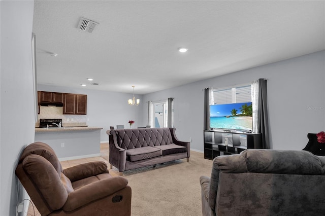 living room with a chandelier, visible vents, light carpet, and baseboards