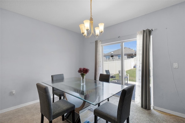 dining space featuring a notable chandelier, baseboards, and carpet floors