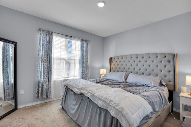 bedroom with baseboards and carpet