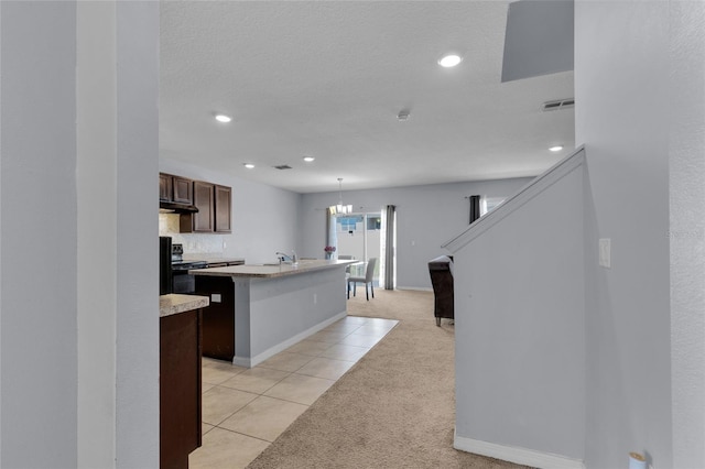 260 Willow Bend Dr, Davenport, FL 33897 - kitchen featuring light carpet, a kitchen island with sink, light countertops, dark brown cabinetry, and under cabinet range hood