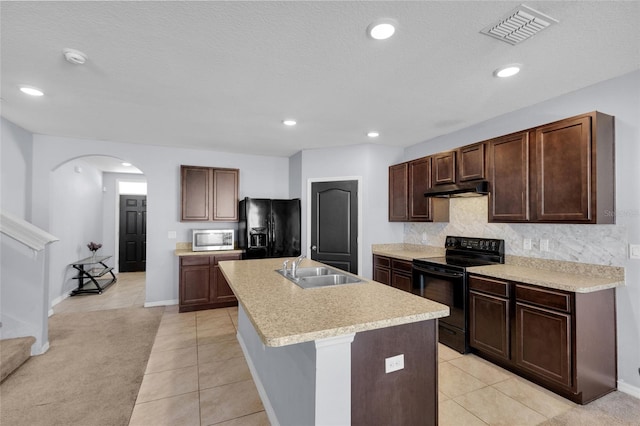 260 Willow Bend Dr, Davenport, FL 33897 - kitchen with black appliances, under cabinet range hood, arched walkways, tasteful backsplash, and light countertops