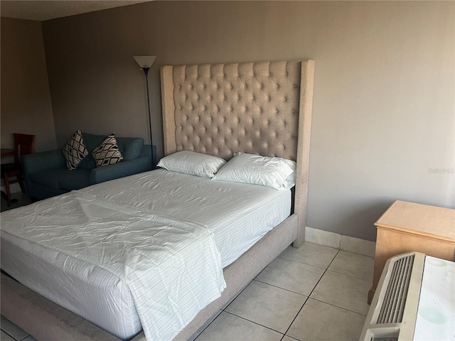 bedroom with light tile patterned floors and baseboards