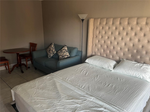 tiled bedroom featuring baseboards