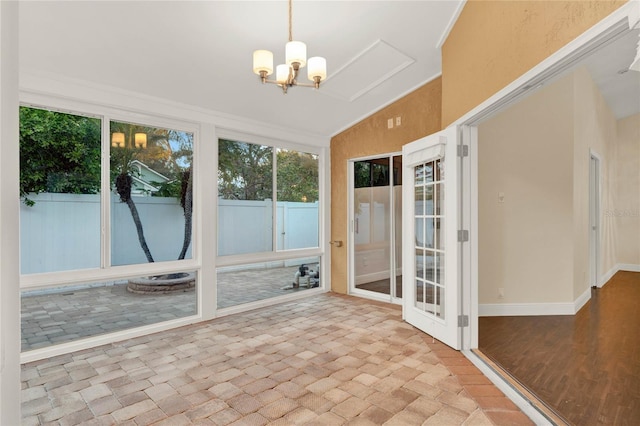 unfurnished sunroom with lofted ceiling and a notable chandelier