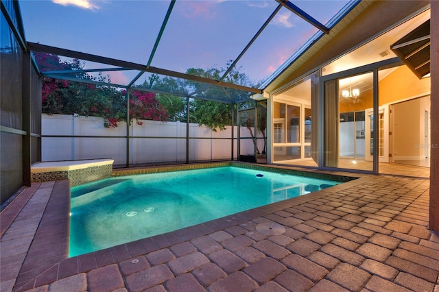 pool at dusk with a patio area, fence, a fenced in pool, and a lanai