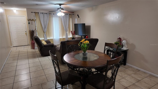 dining space featuring a ceiling fan, visible vents, a textured ceiling, and light tile patterned floors