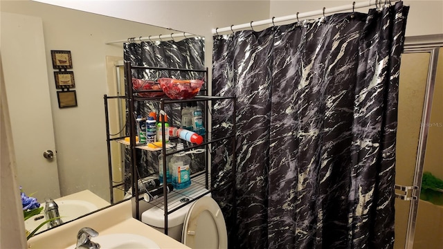 bathroom with curtained shower, a sink, and toilet