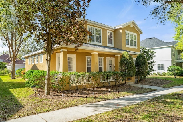 traditional home with a front lawn and stucco siding