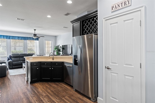 3304 Cat Brier Trl, Harmony, FL 34773 - kitchen with stainless steel appliances, a peninsula, visible vents, open floor plan, and dark wood finished floors