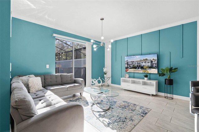 living room featuring an inviting chandelier, baseboards, and crown molding