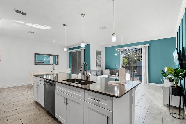 kitchen featuring dark countertops, visible vents, stainless steel dishwasher, white cabinets, and a sink