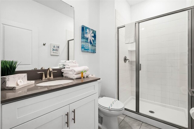 bathroom with tile patterned flooring, a shower stall, toilet, and vanity