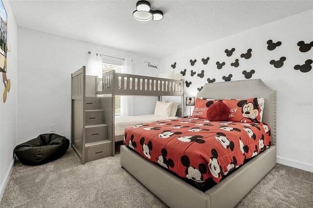 carpeted bedroom featuring baseboards and a textured ceiling