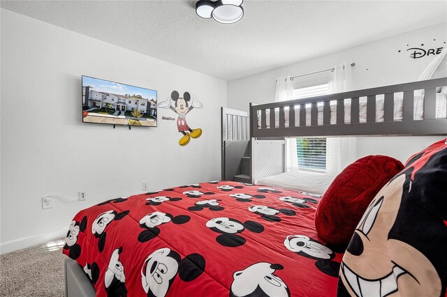 bedroom featuring carpet, a textured ceiling, and baseboards