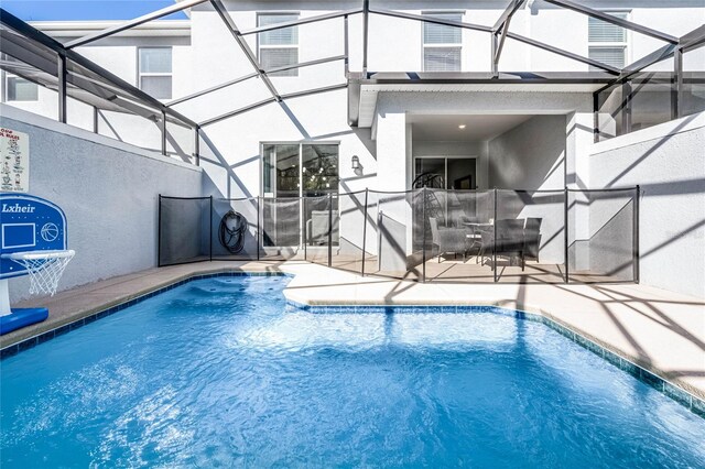 pool with a patio area and glass enclosure