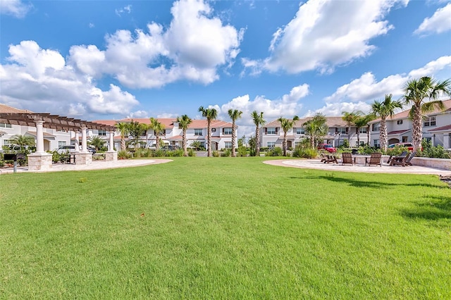 view of community featuring a residential view, a pergola, and a yard