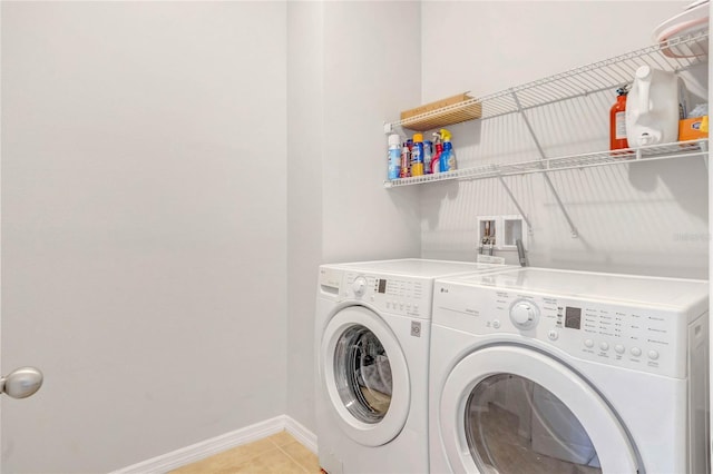 laundry area with light tile patterned floors, baseboards, laundry area, and washer and clothes dryer