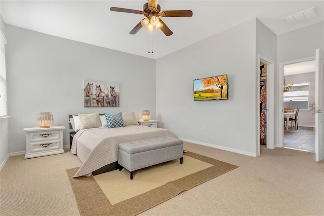 carpeted bedroom with a walk in closet, ceiling fan with notable chandelier, baseboards, and visible vents